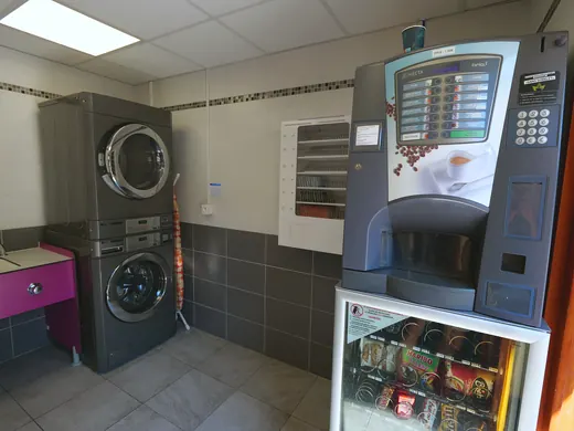 Wasruimte van Camping des Neiges: wasmachines, drogers en drankenautomaat